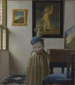 Jeune femme debout dans un baroque virginal Johannes Vermeer